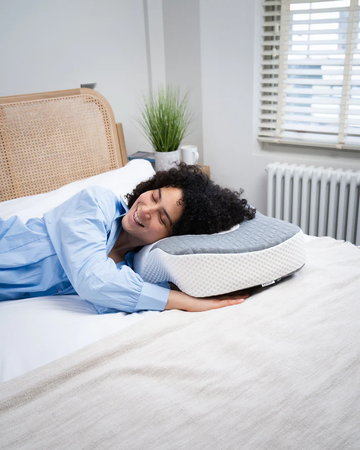 A woman is lying on Elviros pillow for neck pain relief