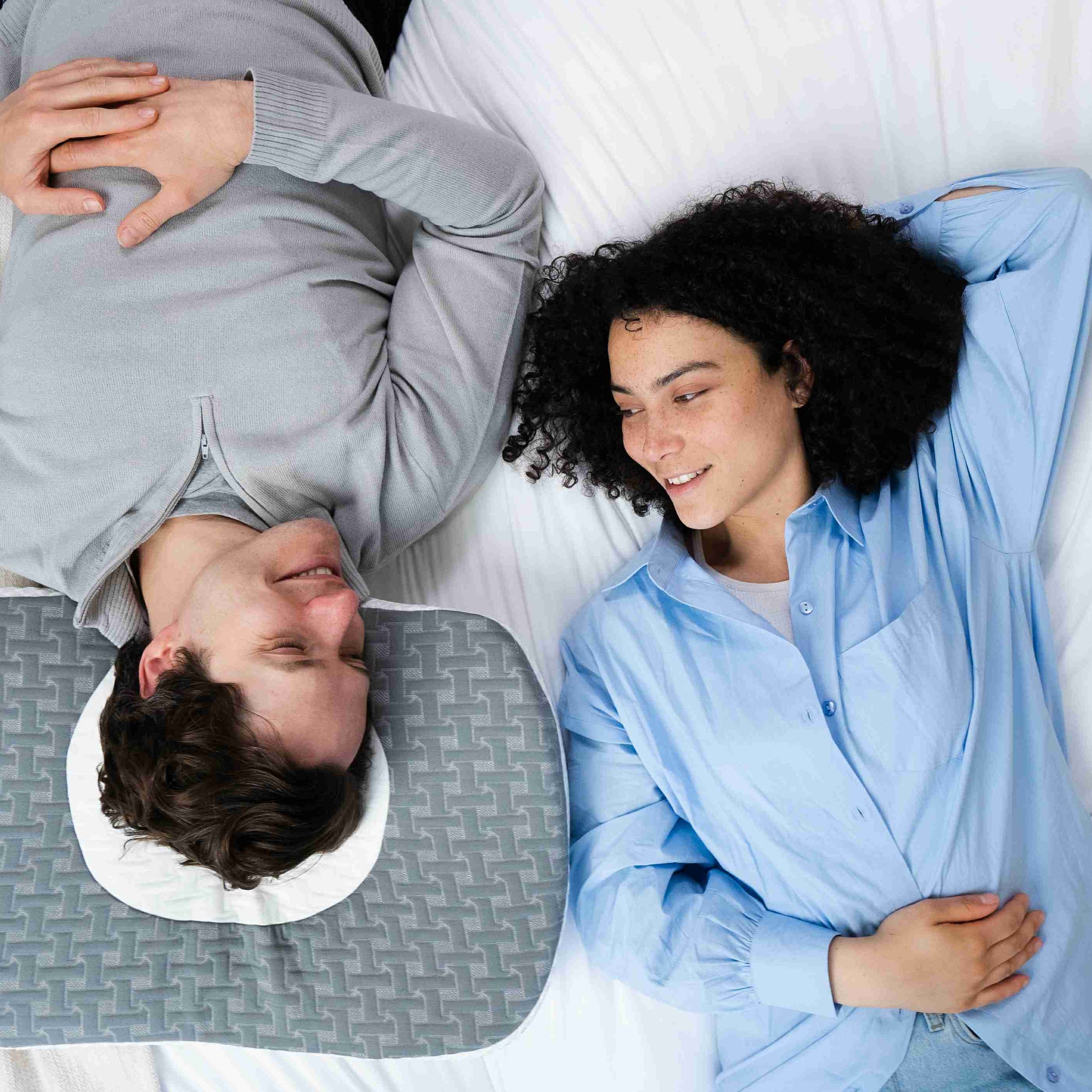 A young couple is lying on Elviros side sleeper pillow