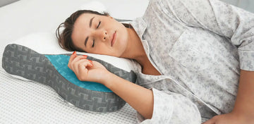A woman is sleeping peacefully on an Elviros contour pillow.