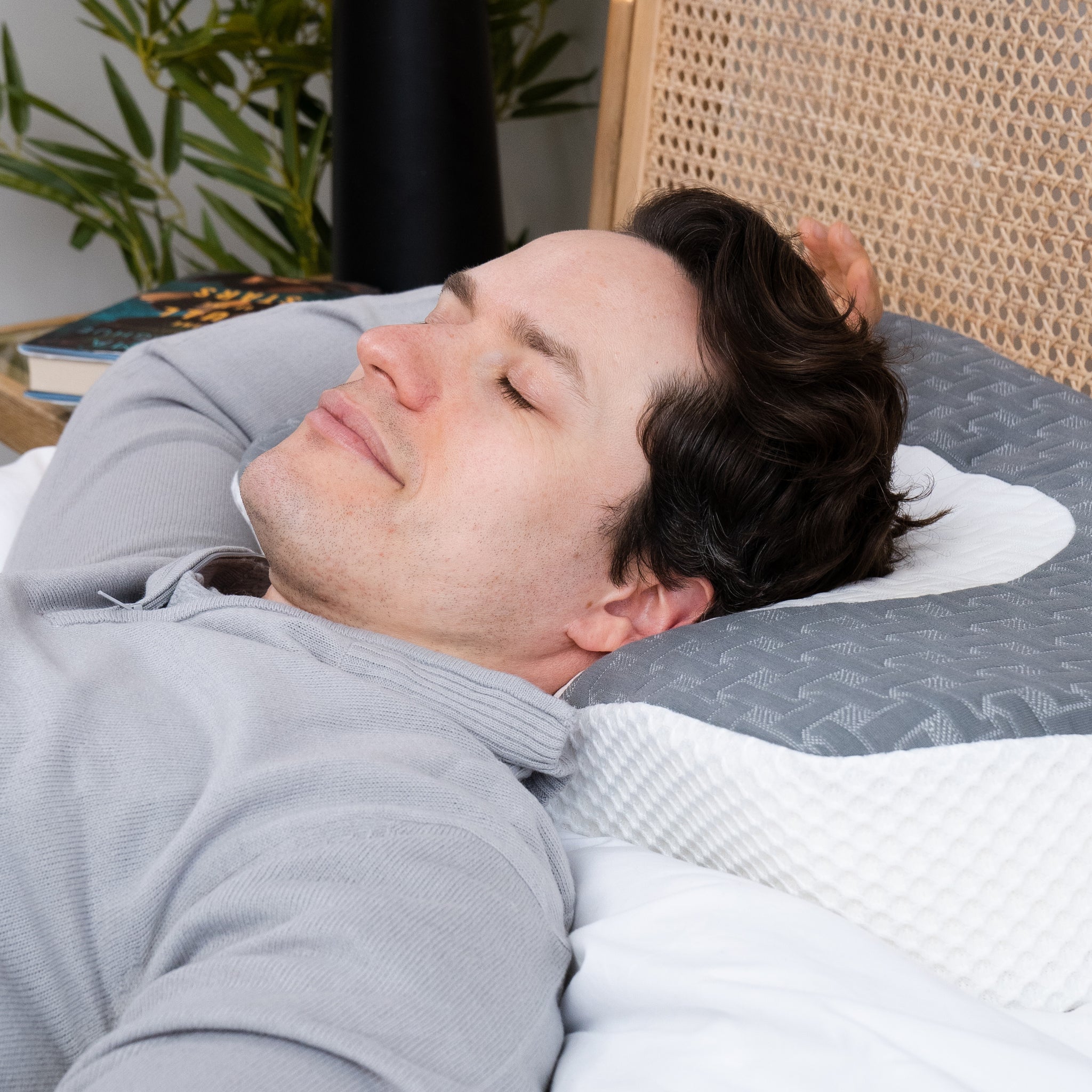 A man is peacefully sleeping on an Elviros pillow, his head comfortably cradled by the pillow's ergonomic design.